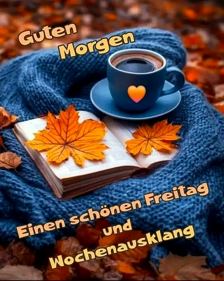 Ein blauer Kaffeebecher mit einem Herzmotiv auf einer Untertasse liegt auf einem blauen Schal neben einem Buch mit Herbstlaub. Der Hintergrund ist mit Herbstlaub gefüllt.