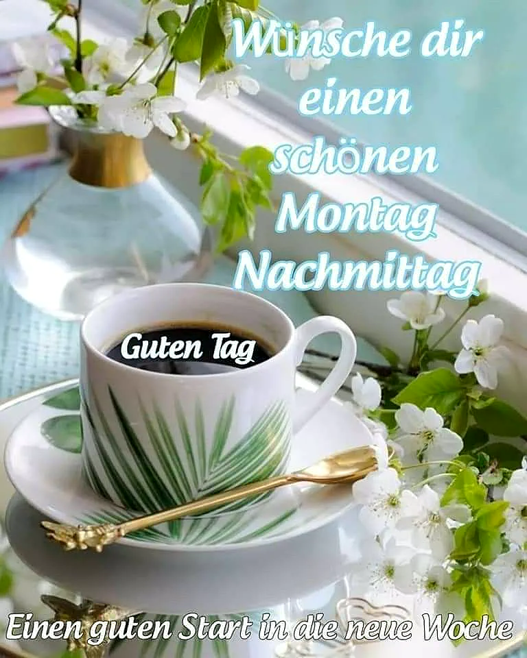 Ein Foto von einer Tasse Kaffee auf einem Tisch neben einem Fenster, umgeben von weißen Blumen und einem goldenen Löffel. Die Tasse hat ein grünes Muster und steht auf einem weißen Unterteller. Im Hintergrund ist ein Blumenstrauß in einer Vase zu sehen. Das Licht fällt durch das Fenster und taucht die Szene in ein warmes Licht.